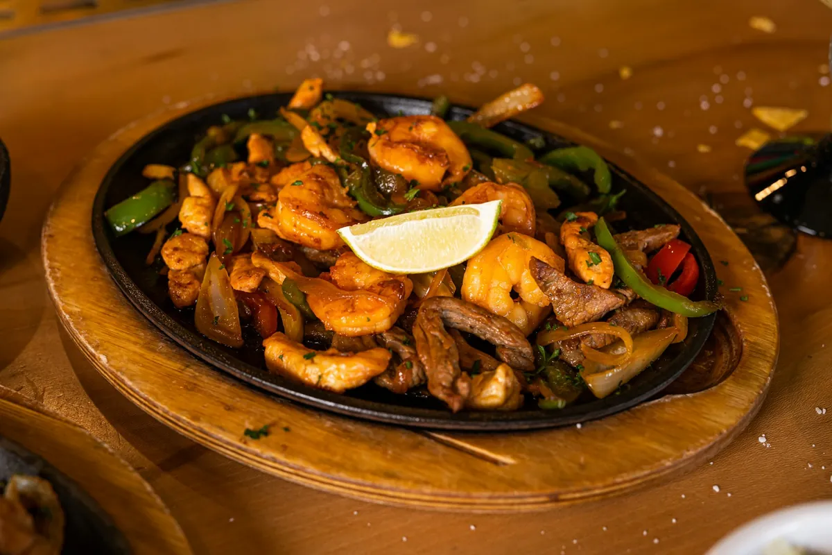 Grilled shrimp with peppers and onions on a skillet